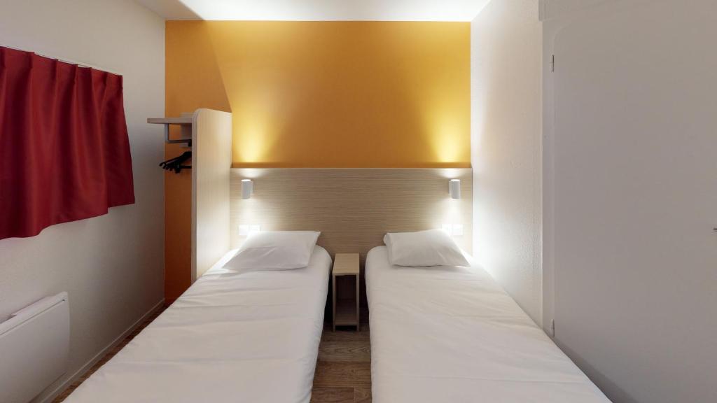 ランスにあるPremière Classe Reims Ouest - Tinqueuxの黄色い壁の部屋のベッド1台