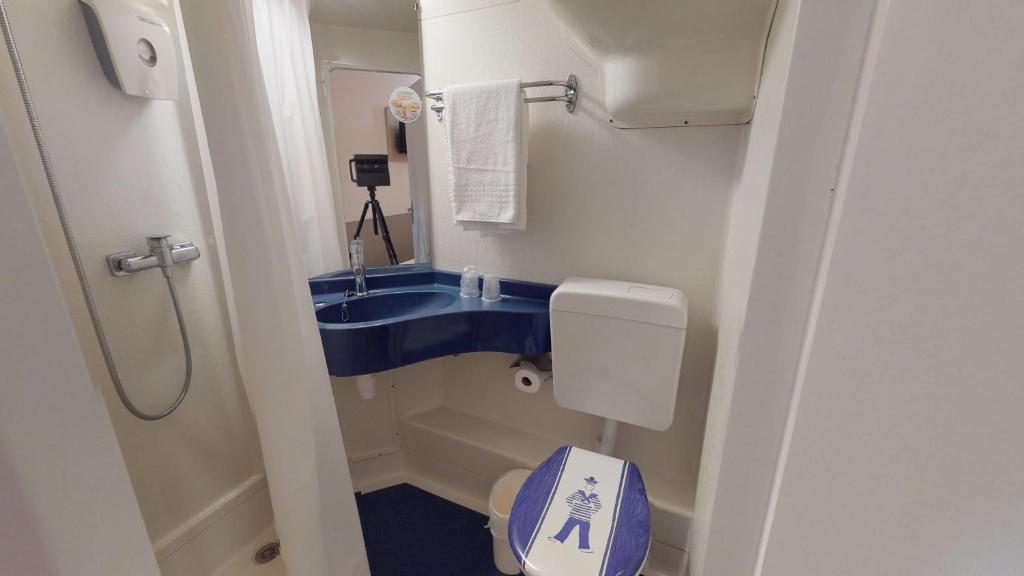a bathroom with a toilet and a sink in an airplane at Première Classe Reims Ouest - Tinqueux in Reims