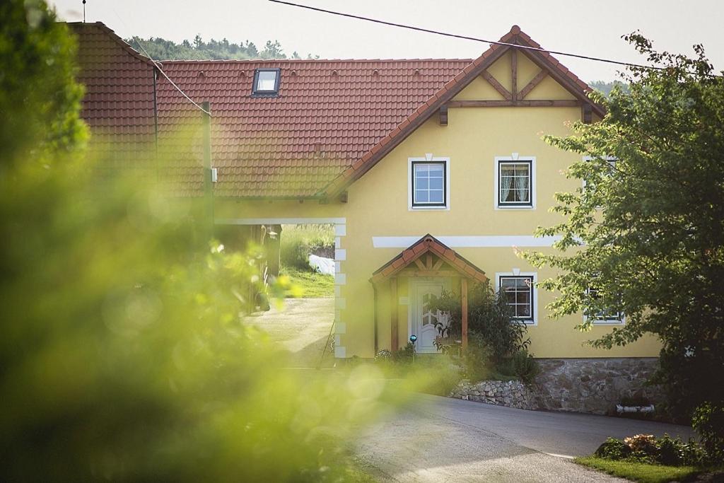 ein gelbes Haus mit rotem Dach in der Unterkunft Gästehaus Gnant in Winten