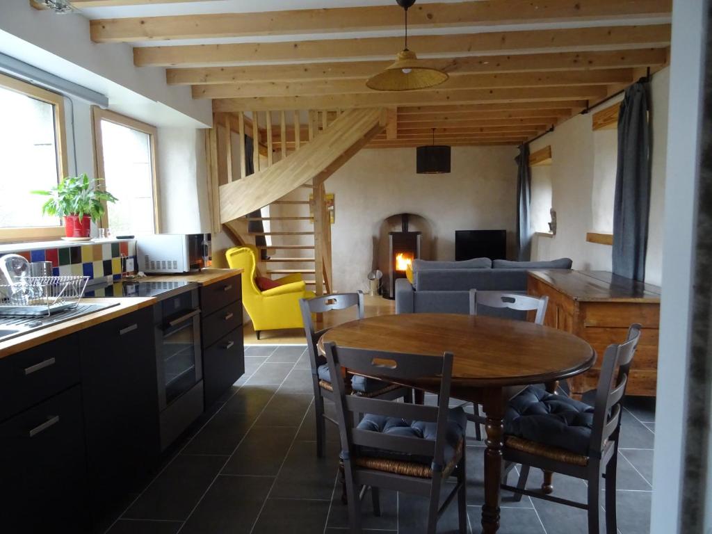 uma cozinha e sala de estar com mesa e cadeiras em Gites du Hérisson em Bégard