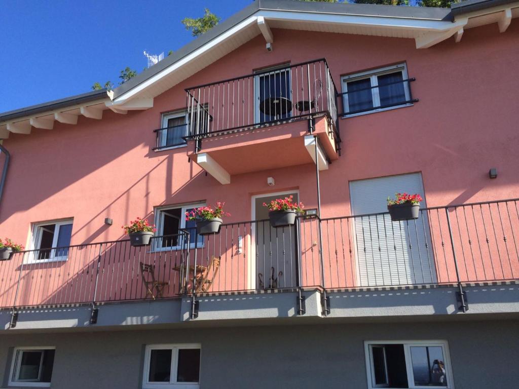 a pink building with potted plants on the balconies at Casa Vacanze Como Brunate in Brunate