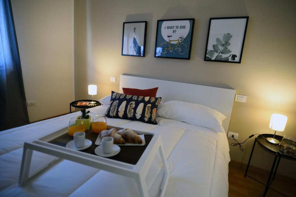 Una cama blanca con una bandeja de comida. en Pyramis Room, en Pontecagnano Faiano