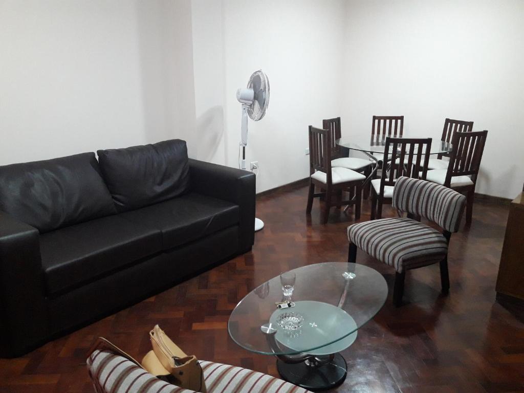 sala de estar con sofá, mesa y sillas en Departamento Céntrico Ciudad de Mendoza en Mendoza