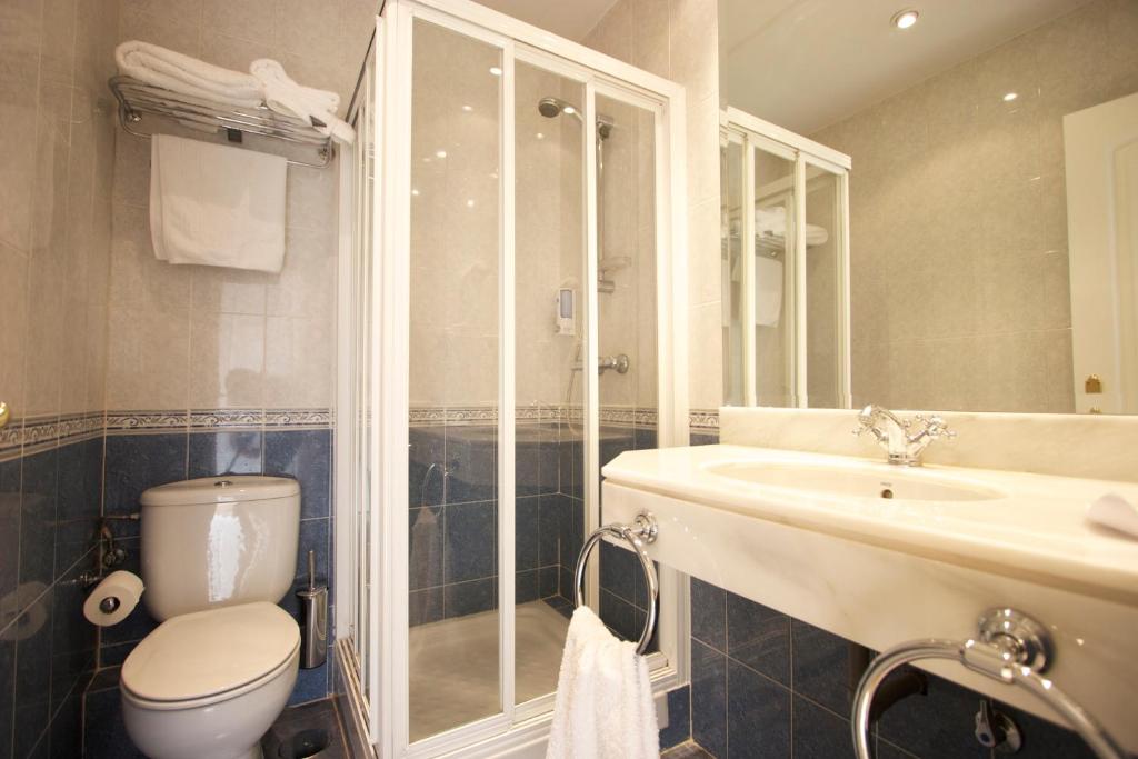 a bathroom with a toilet and a sink and a shower at Rincón de Gran Vía in Madrid