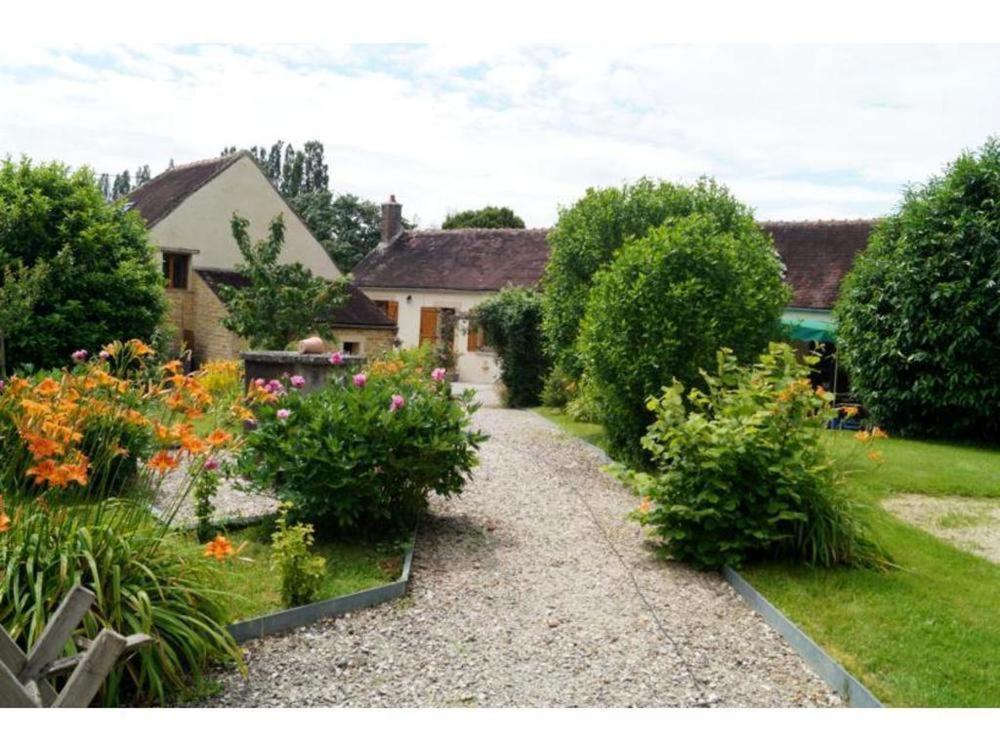 a garden with some flowers and a house at Le verger Fleuri in Vallières