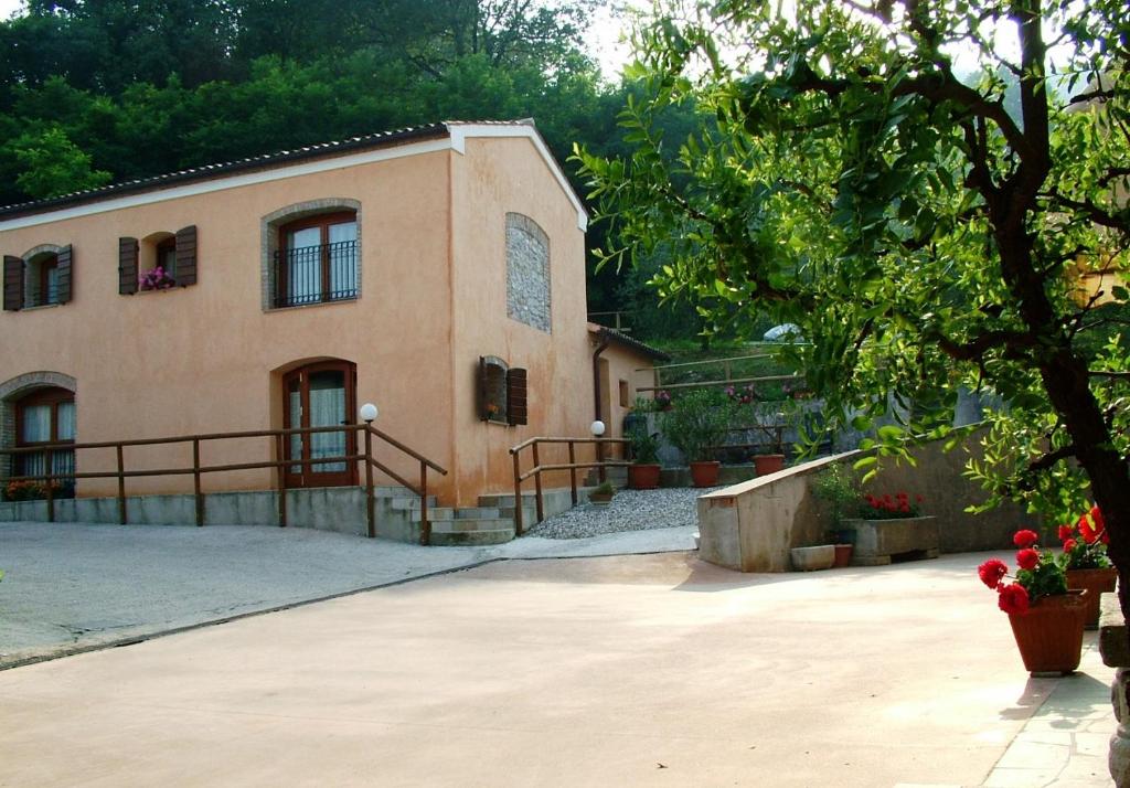 una grande casa con un albero di fronte di agriturismo la scuderia a Galzignano