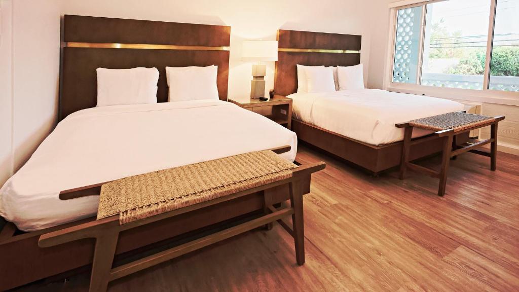 a hotel room with two beds and a window at Sunset Inn in Islamorada