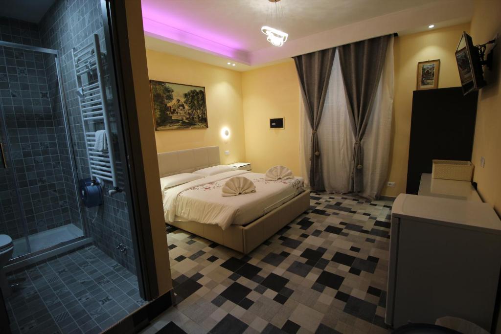 a bedroom with a bed and a bathroom with a shower at Quest House Lihong in Rome