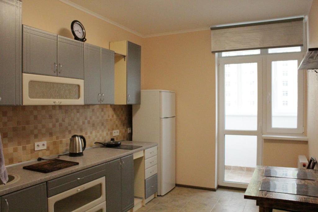 eine Küche mit einem weißen Kühlschrank und einem Fenster in der Unterkunft Апартаменты на Каблукова in Kiew