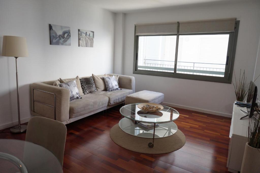 ein Wohnzimmer mit Sofa und Tisch in der Unterkunft Happy Holiday Beach Home in Sitges