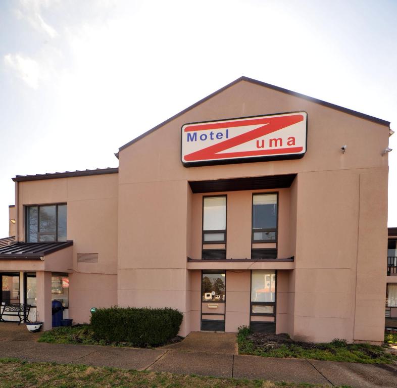 a mobil oil building with a sign on it at Motel Zuma in Williamsburg