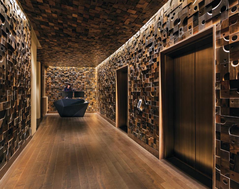 a bathroom with a stone wall and a black door at Nobu Hotel at Caesars Palace in Las Vegas