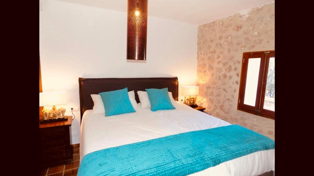 1 dormitorio con 1 cama grande con almohadas azules en C'an Co Banyalbufar, en Banyalbufar