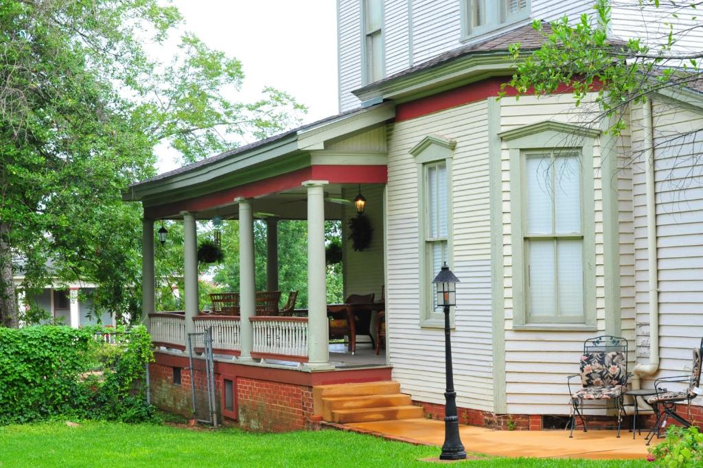 a screened porch on a house with a table at Hardeman House Bed and Breakfast in Nacogdoches