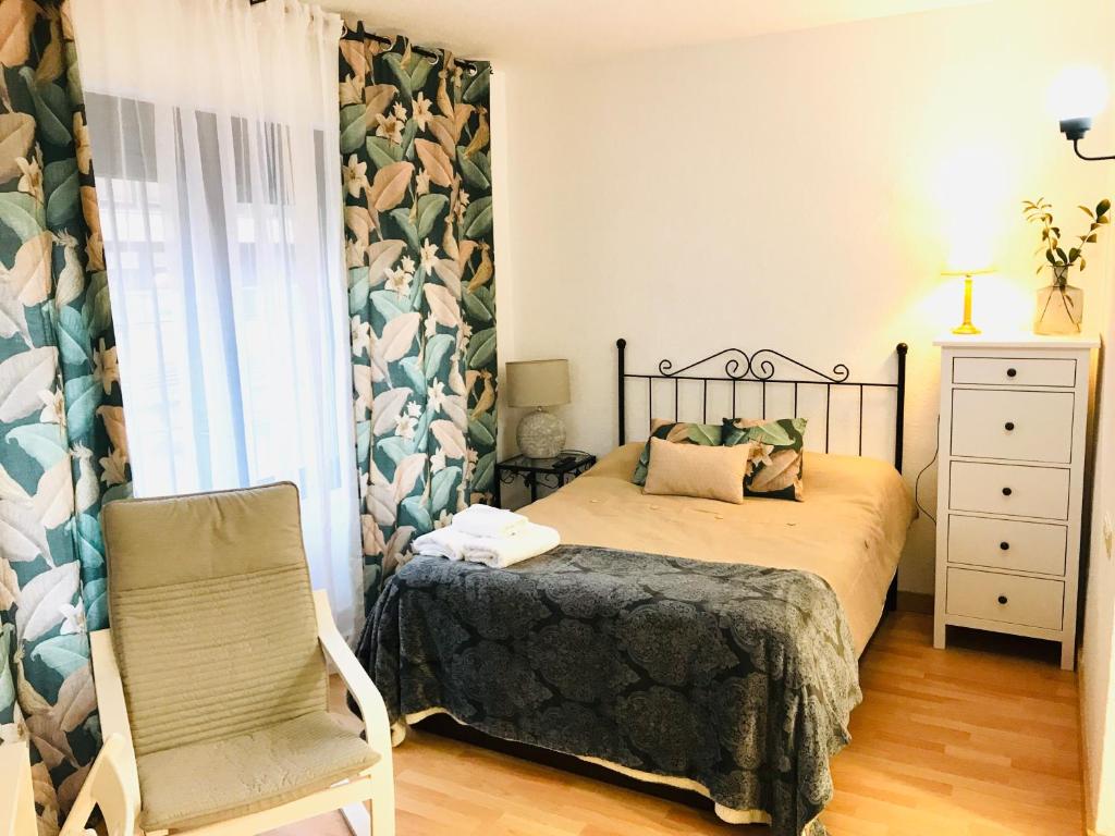ein Schlafzimmer mit einem Bett und einem Stuhl in der Unterkunft Resitur Luxury Apartment 114 in Sevilla