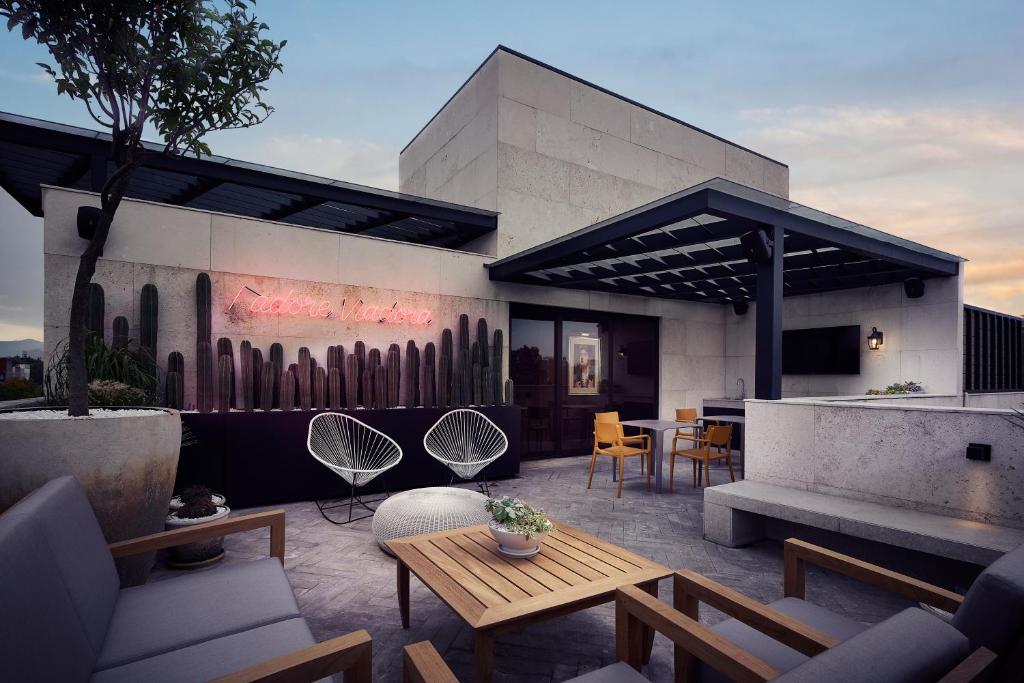 a patio with a table and chairs and a building at Frida by Viadora in Mexico City