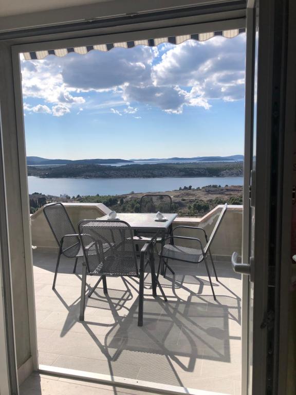 ein Tisch und Stühle auf einem Balkon mit Aussicht in der Unterkunft Apartments Galic in Šibenik