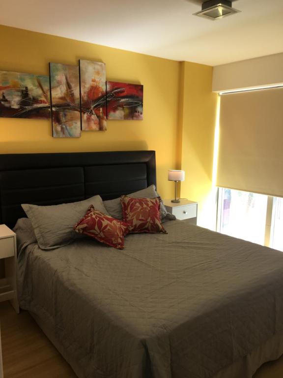 um quarto com uma cama com duas almofadas em Boulogne Design Suites em Mendoza