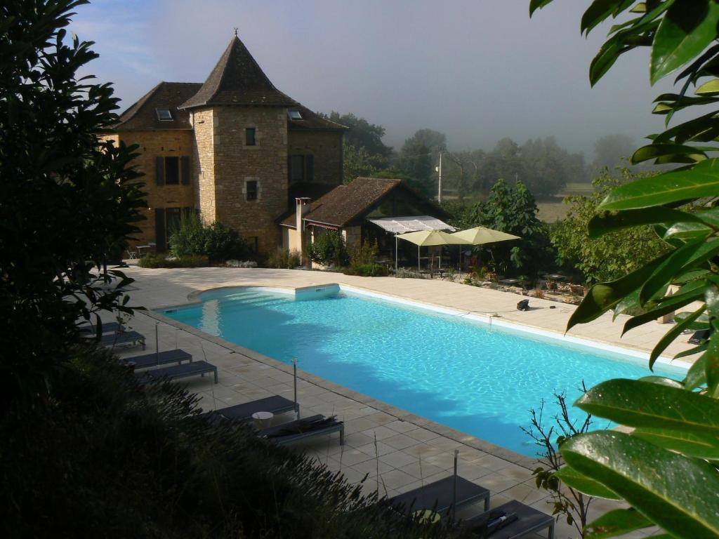 a large swimming pool in front of a building at Hotel La Bastie d'Urfé in Naussac