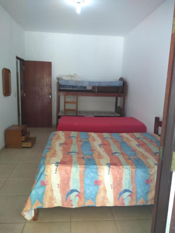 a bedroom with a bed with a colorful comforter at Recanto dos Sonhos in Vargem