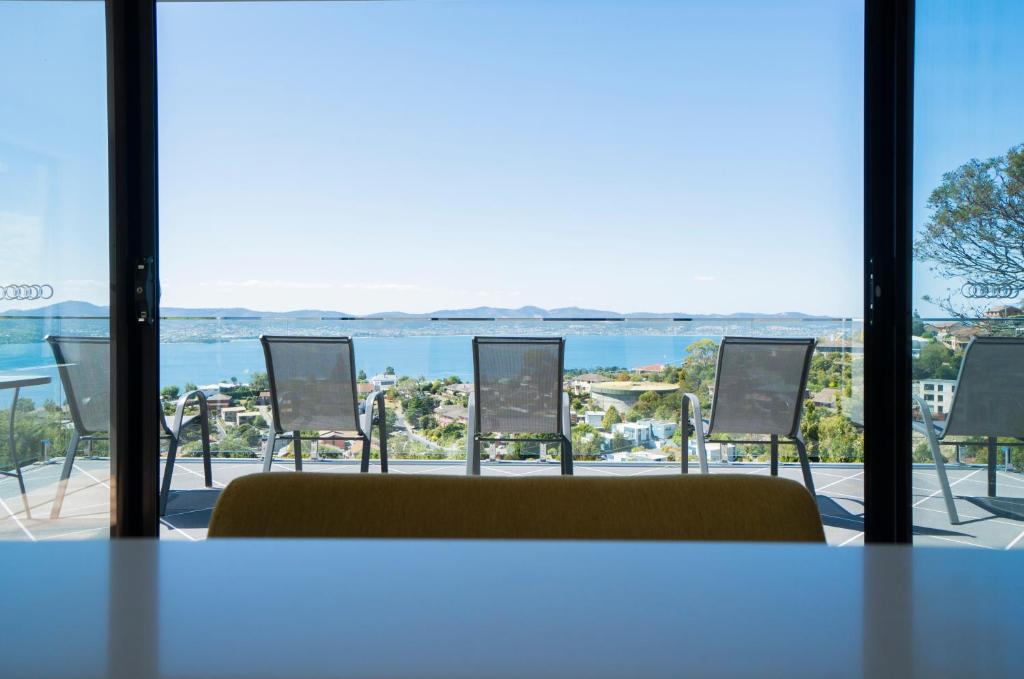 a room with chairs and a view of the water at Amazing Sea Views Luxury Guest House in Hobart