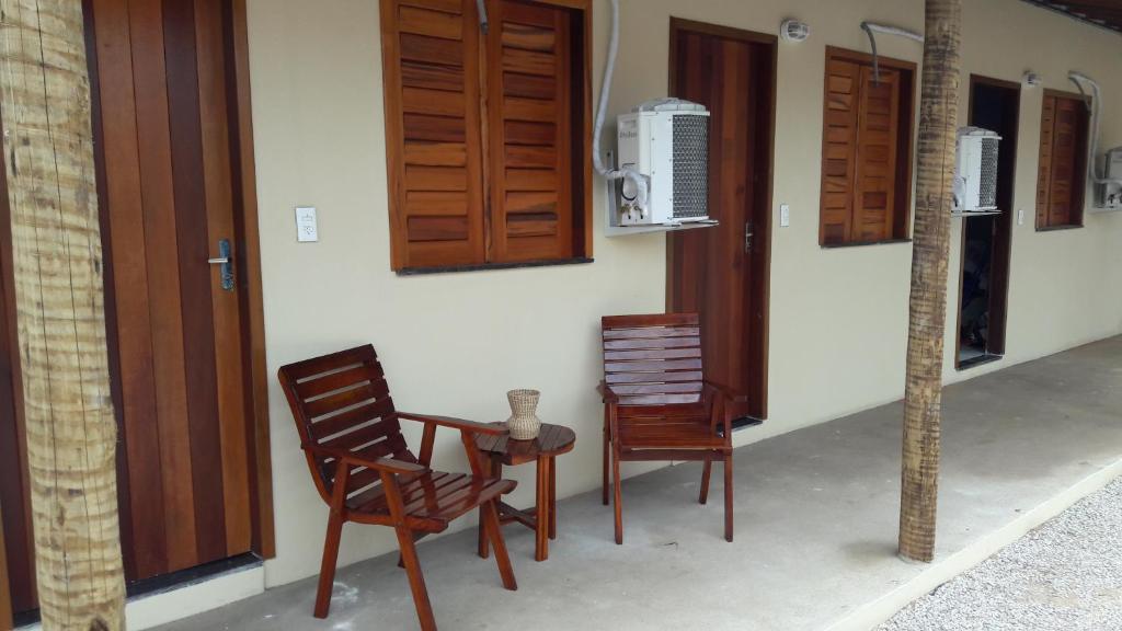 2 Stühle und ein Tisch vor einem Haus in der Unterkunft Villa Portal dos Ventos in Fortim