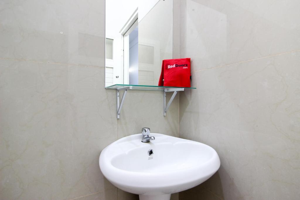 un bagno con un lavandino bianco e uno specchio di Griya Izzara Guest House Syariah a Sleman