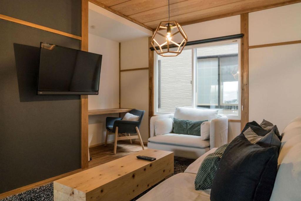 een woonkamer met een bank en een tv bij Nozawa Gondola Apartments in Nozawa Onsen