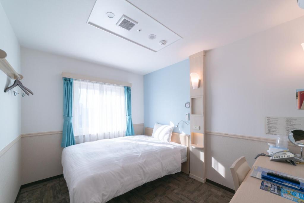 1 dormitorio con cama blanca y ventana en Toyoko Inn Daegu Dongseongro en Daegu