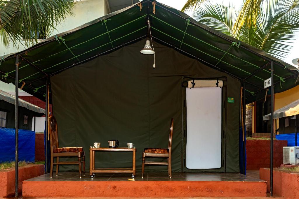 a green tent with two chairs and a table at Tent-O-Treat Premium Rooms near Dapoli in Dapoli