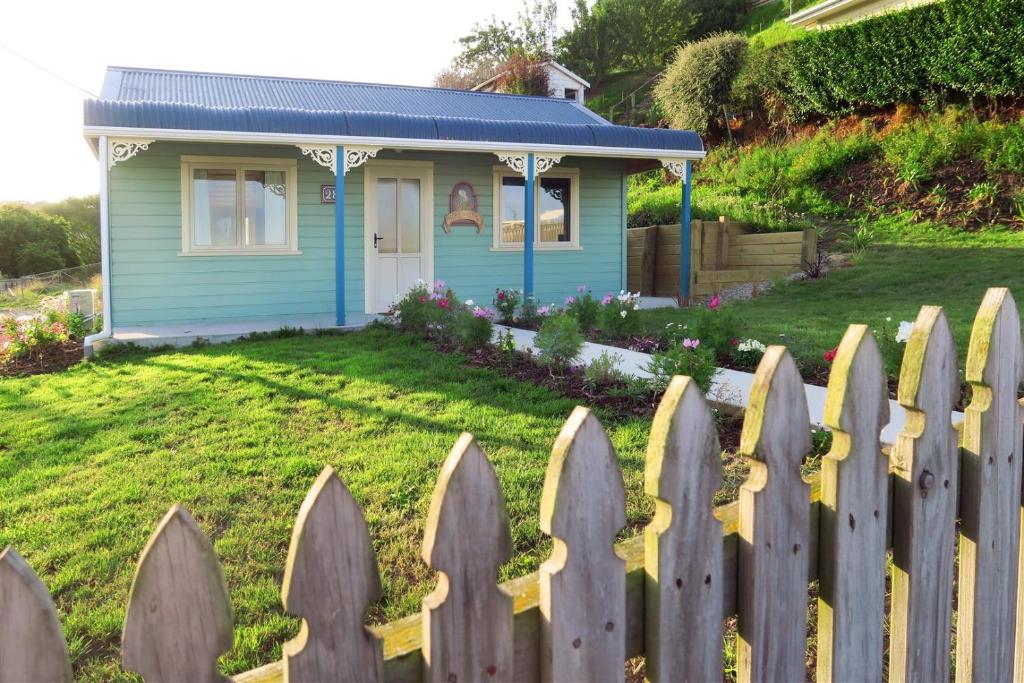 a picket fence in front of a small house at Fantail Cottage in Oamaru