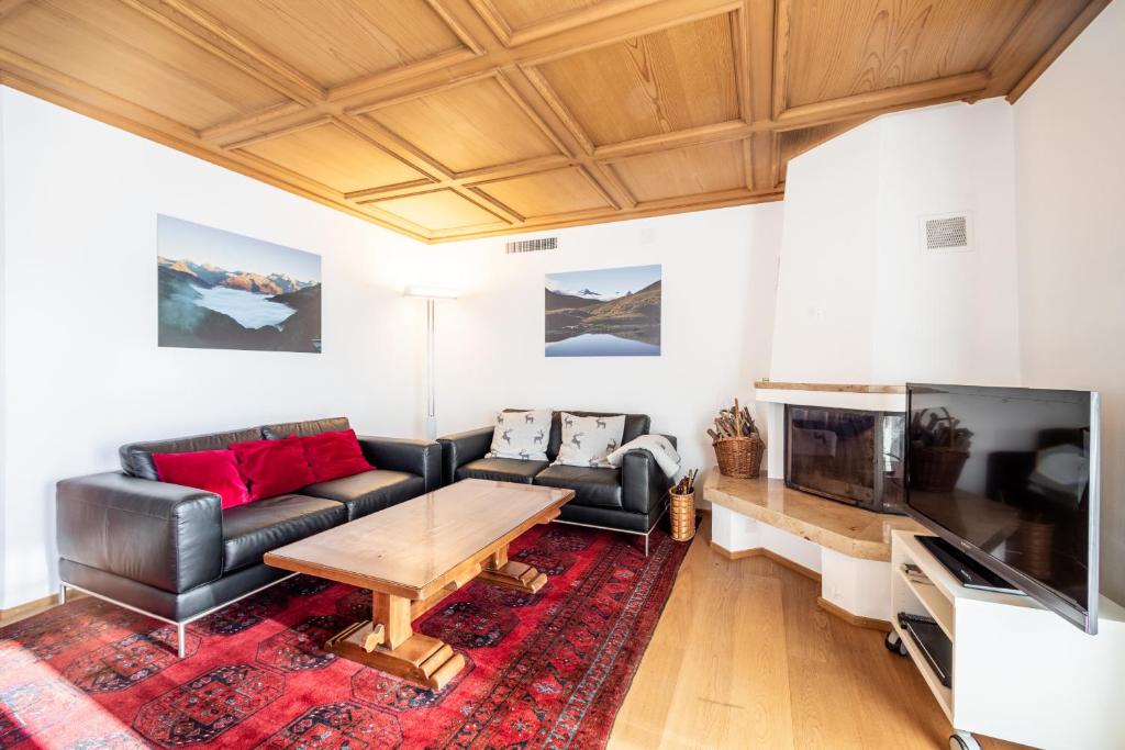 ein Wohnzimmer mit einem Sofa und einem Tisch in der Unterkunft Casa Murissen in Flims