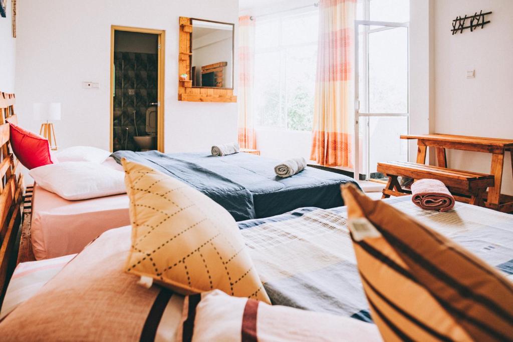 a room with three beds and a window at Hugging Clouds in Nallathanniya