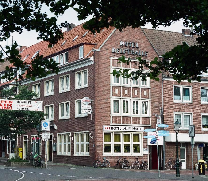 un gran edificio de ladrillo en una calle de la ciudad en Hotel Delfthalle en Emden