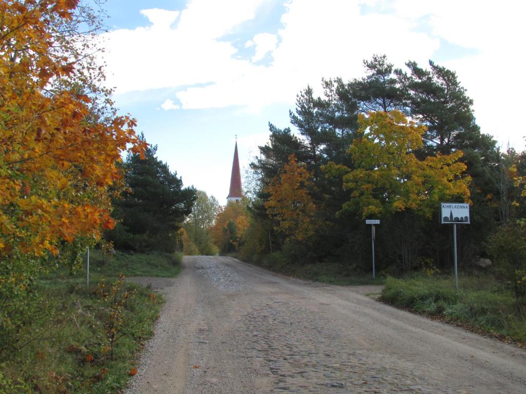 a dirt road with a church in the distance at Kihelkonna Jahimaja majutus in Kihelkonna