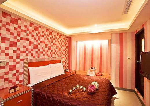 ein Hotelzimmer mit einem Bett mit Blumen darauf in der Unterkunft Meets Happy Hotel in Yonghe
