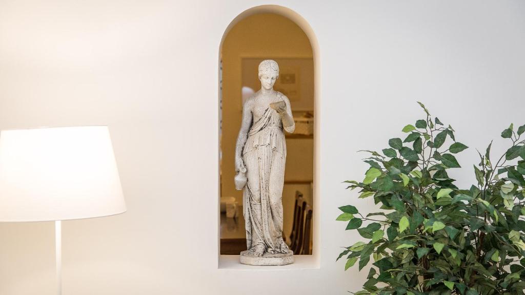 una estatua de una mujer parada frente a un espejo en Atheneum by Rental in Rome, en Roma