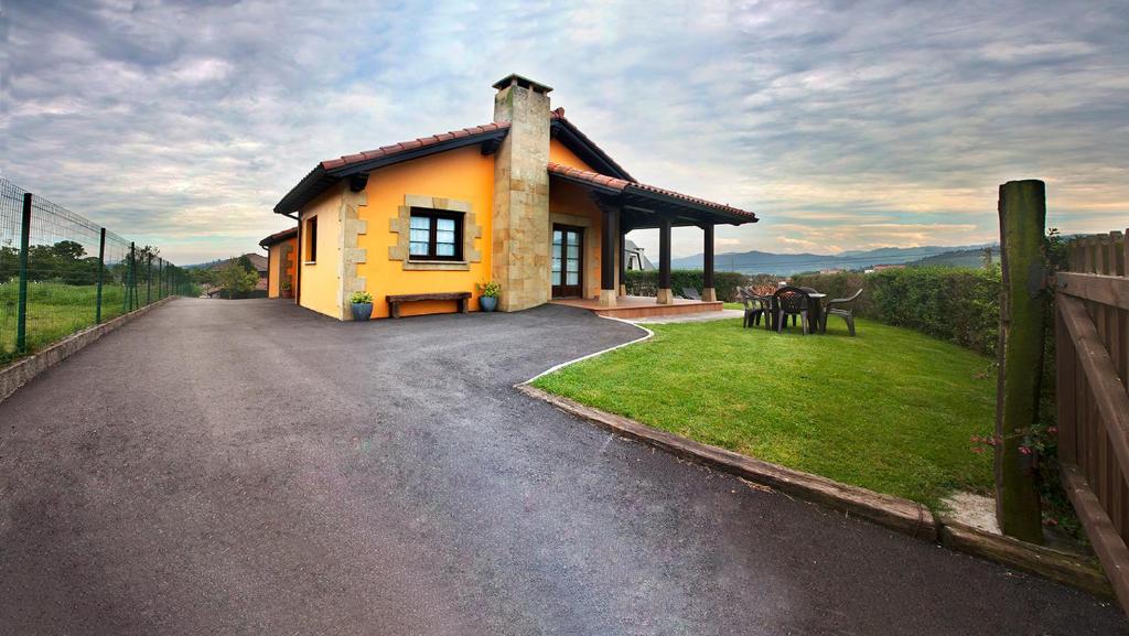 una pequeña casa amarilla al lado de una carretera en Casa SOPALACIO en Zurita