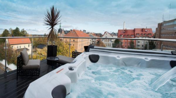 a hot tub on the balcony of a building at First Hotel Central in Norrköping