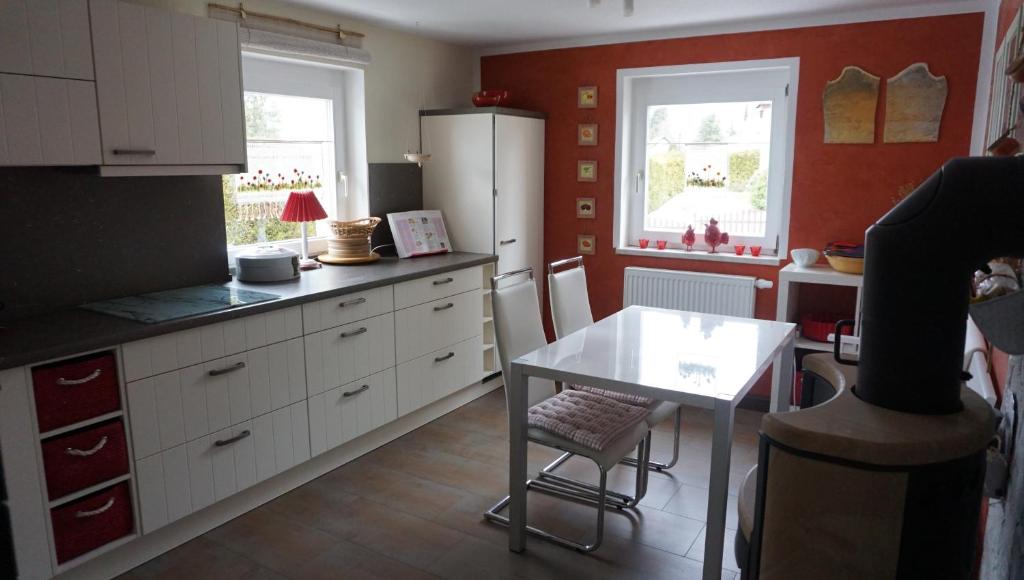 a kitchen with a white refrigerator and a table at Ferienwohnung Ott in Beerheide