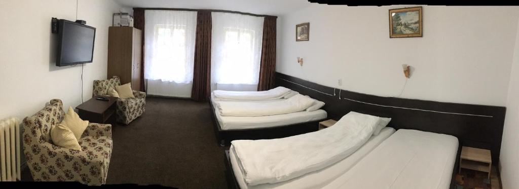 Habitación con 3 camas, sofá y TV. en Iony Apartament, en Sibiu