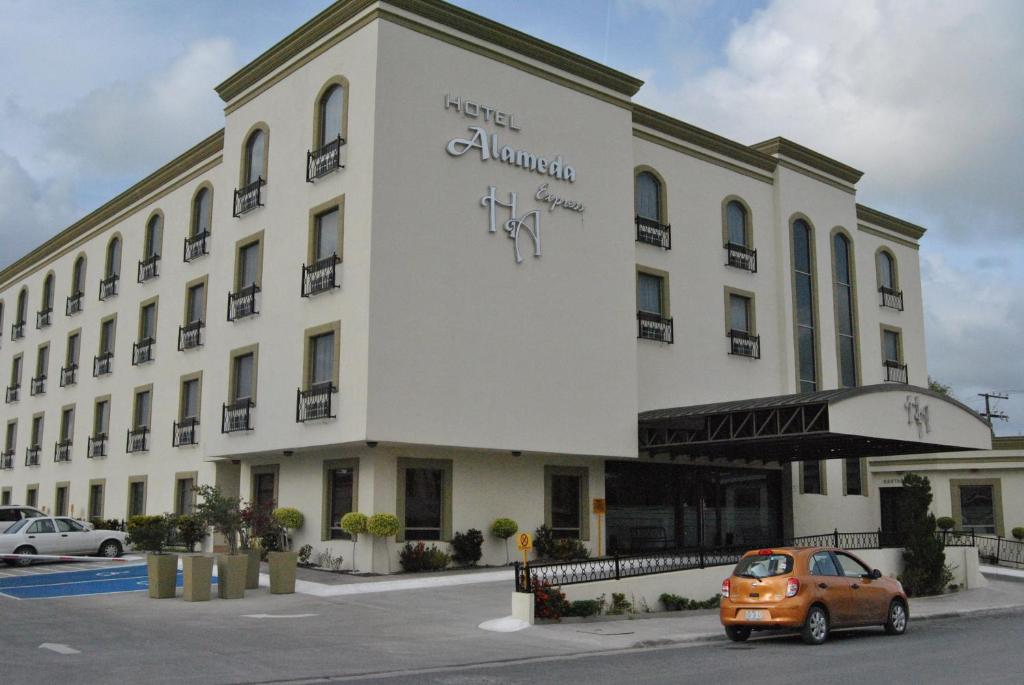 un coche naranja estacionado frente a un edificio en Hotel Alameda Express, en Matamoros