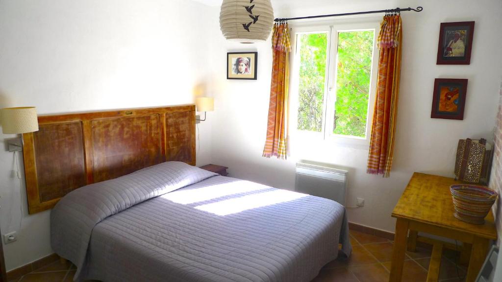 a bedroom with a bed and a window and a table at A ChiOsella in Corbara