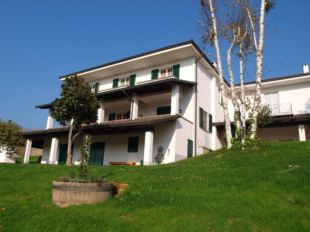 a white building with trees in front of it at Agriturismo Sette Colli in Ferrere