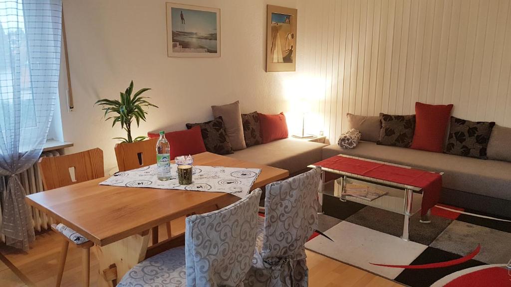 uma sala de estar com uma mesa e um sofá em Galerie-Apartment em Wendelstein