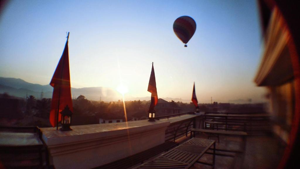a hot air balloon flying over a building with flags at SD View Hotel in Vang Vieng