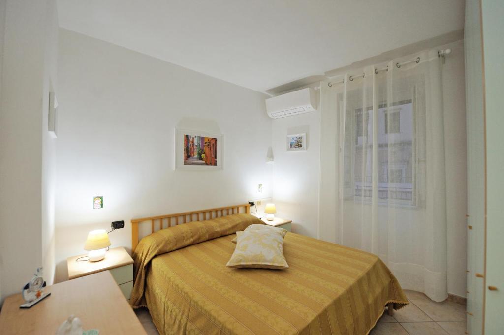 ein Schlafzimmer mit einem Bett, zwei Tischen und einem Fenster in der Unterkunft L'Ancora di Amalfi in Amalfi