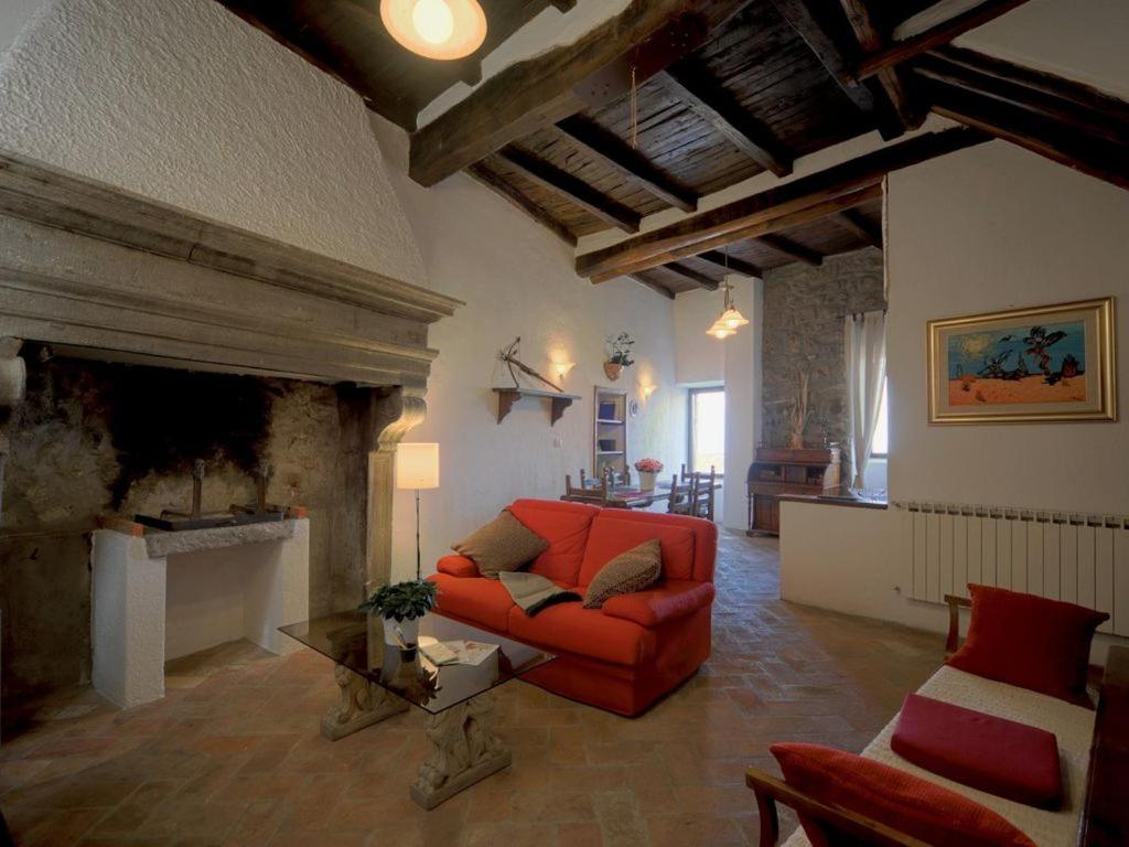 a living room with a red couch and a fireplace at Historic house in Montefiascone