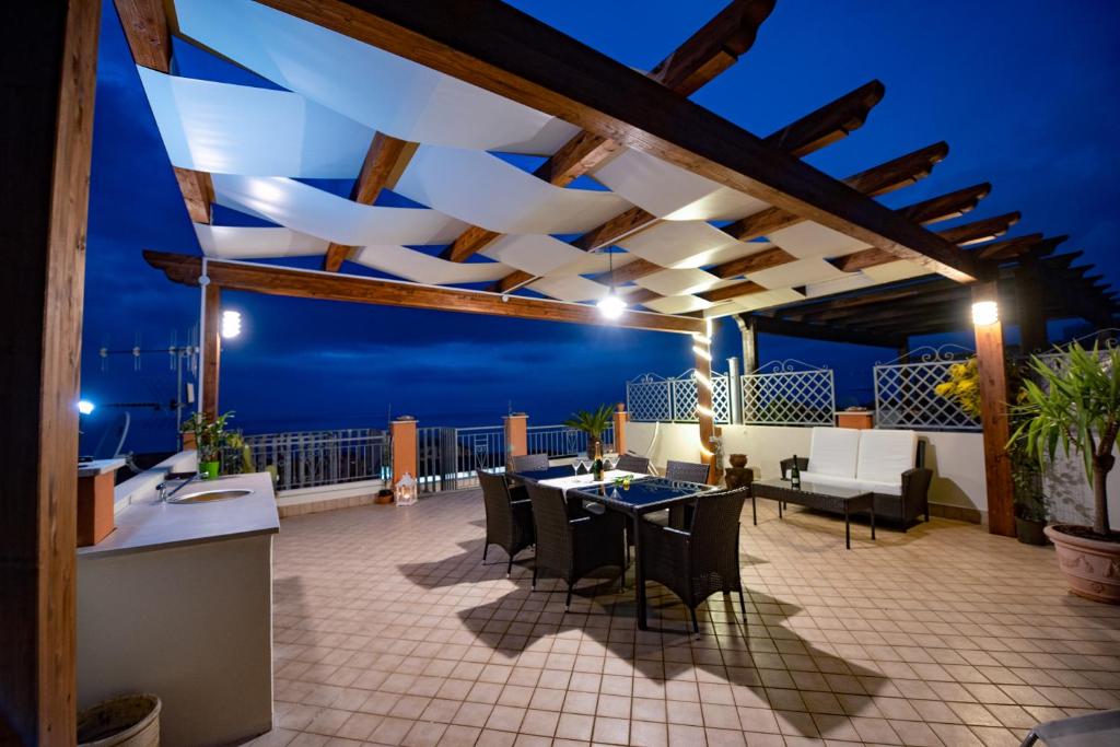 un patio con tavolo, sedie e vista sull'oceano di Sunset Penthouse a Pizzo