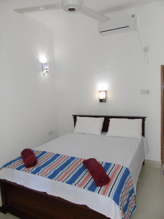 a bedroom with a large bed with red pillows at Eco Villa - Sinharaja in Deniyaya